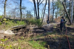 Firefighter wetting down additional areas of the fire